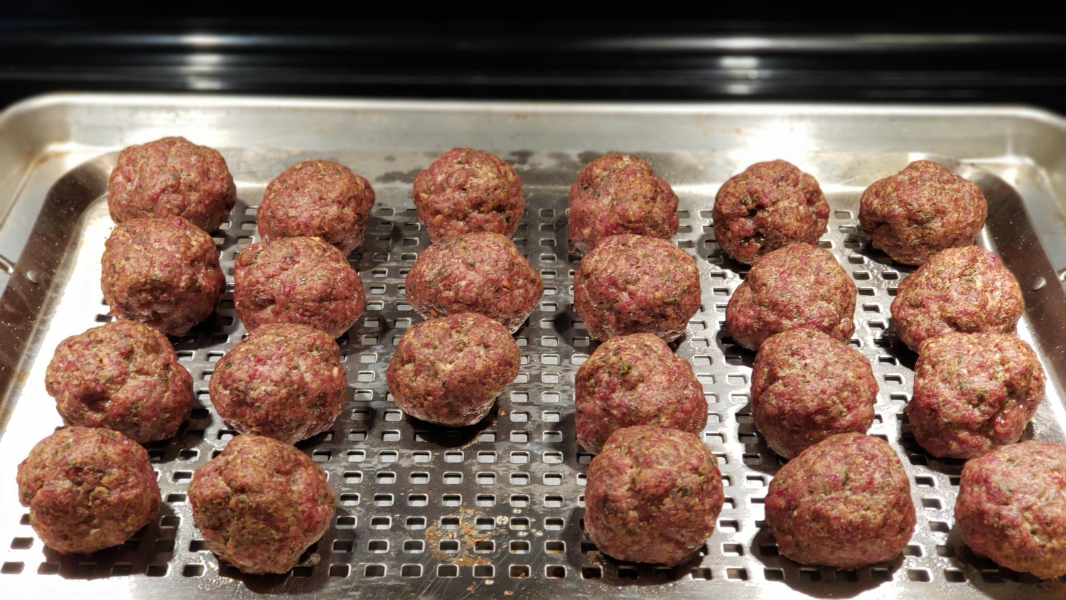 Albóndigas doradas y jugosas cocinadas en freidora de aire servidas en un plato blanco.