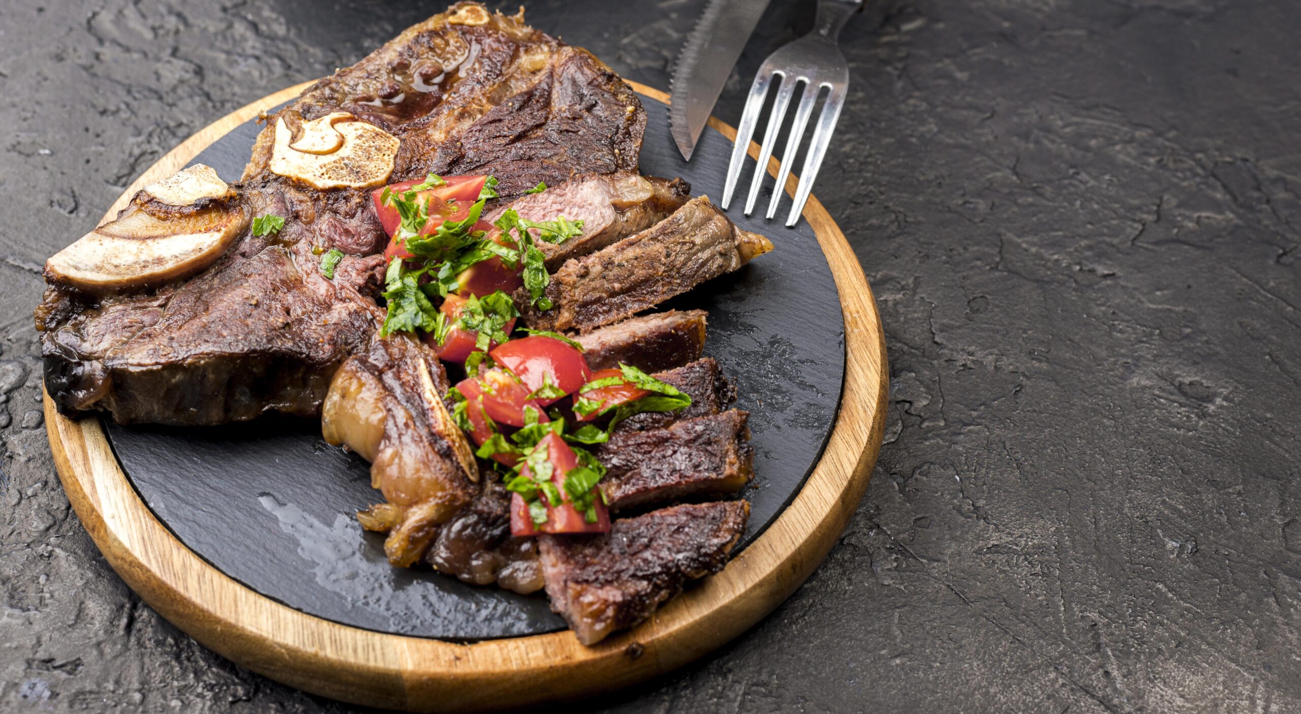 Bistec de res cocinado en una freidora de aire, servido con hierbas frescas y vegetales.