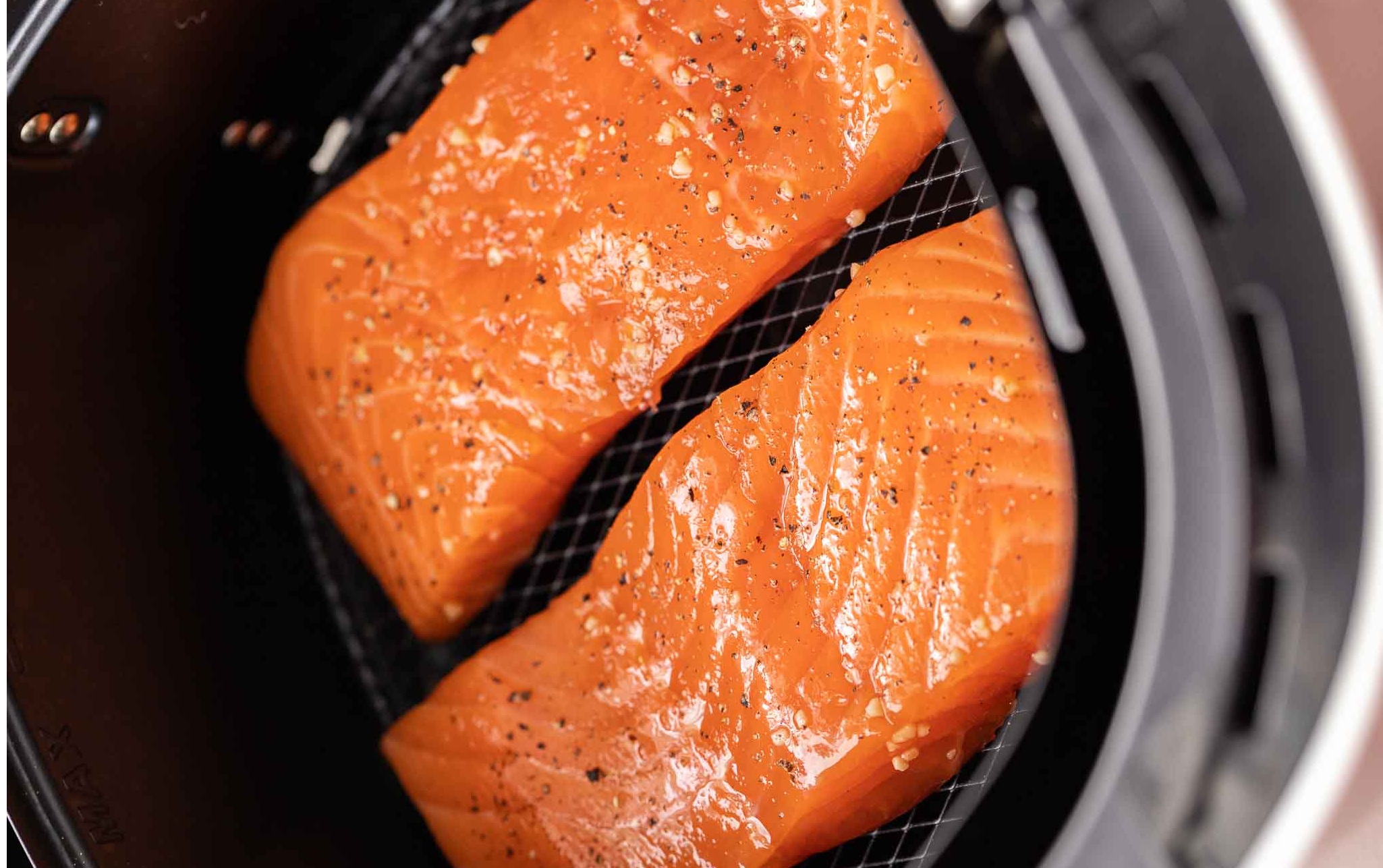 Filete de salmón cocinado en una freidora de aire servido con verduras frescas.
