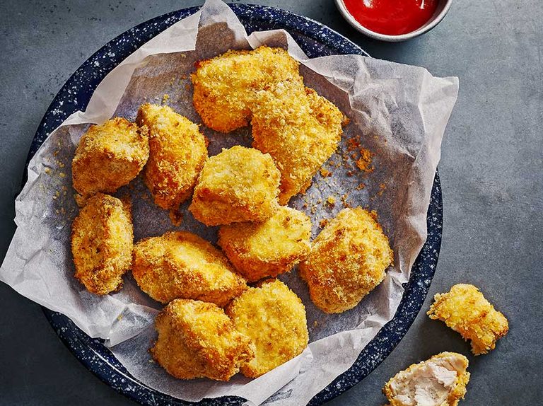 Nuggets de pollo en freidora de aire crujientes y dorados.